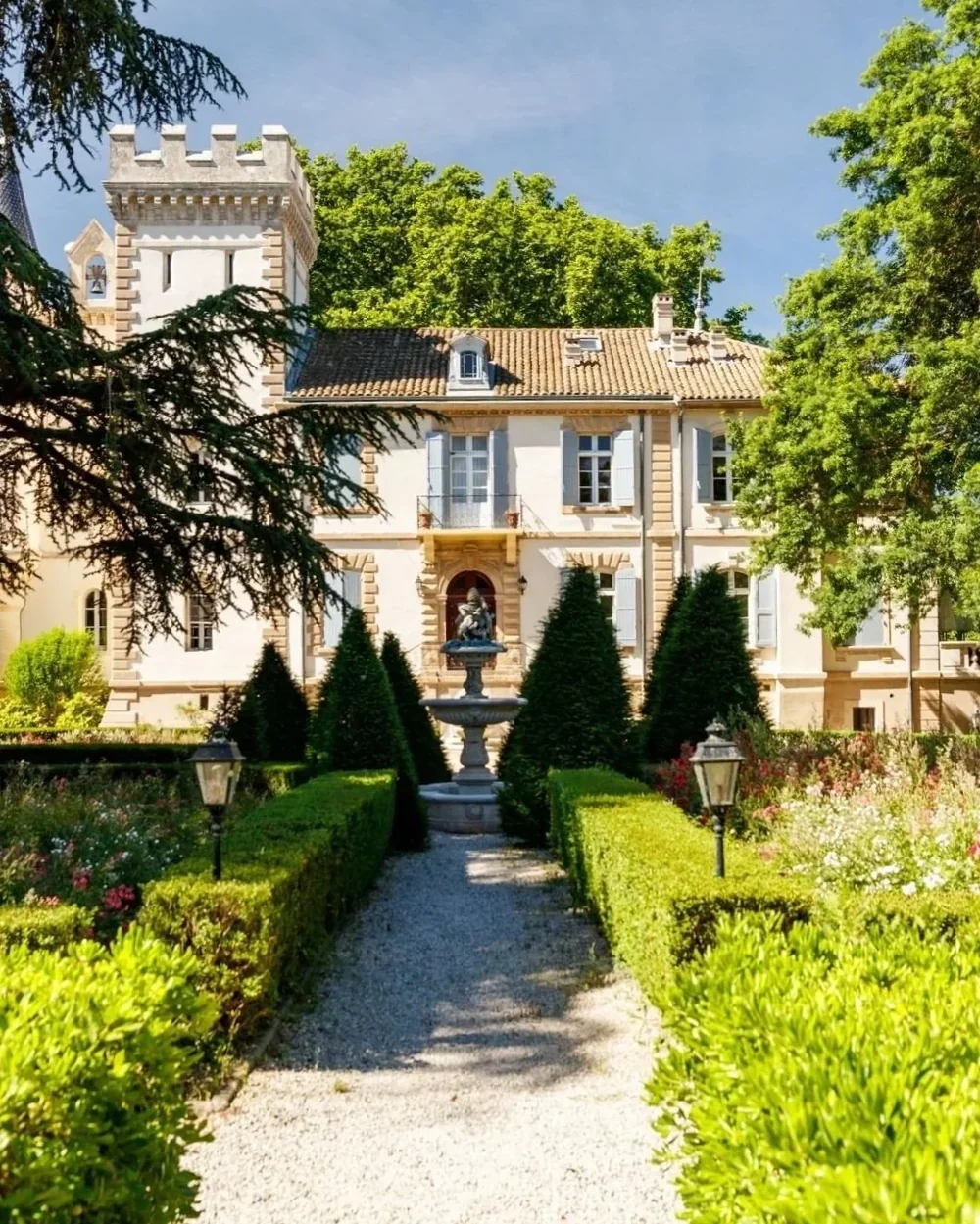 Facade du chateau avec ses jardins fleuris au premier plan, ciel bleu. Belle vue d'ensemble de l'architecture et du parc. Tres valorisant.