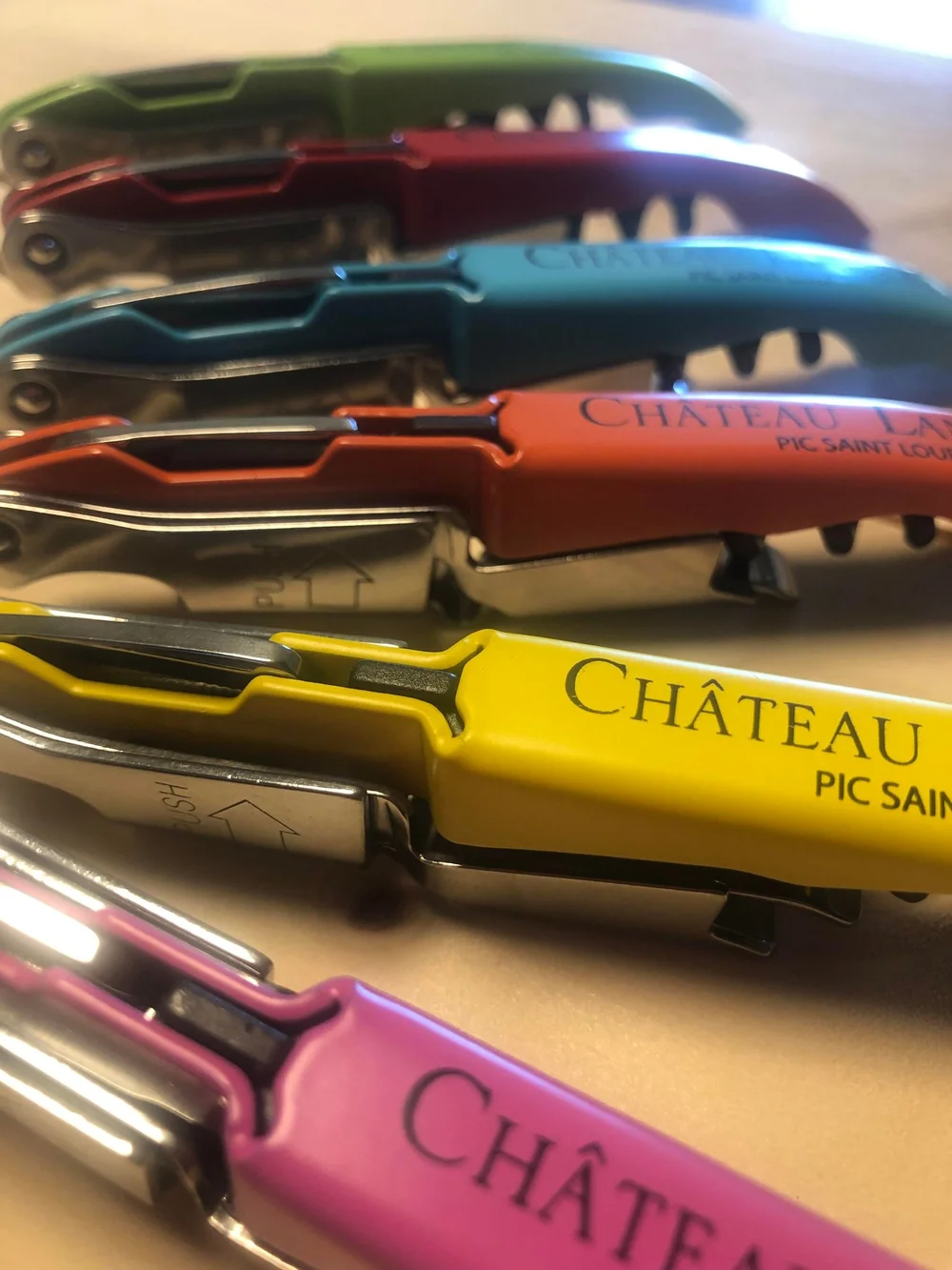 Tire-bouchons sommelier siglés 'Chateau Lancyre Pic Saint Loup' en plusieurs coloris, gros plan. Detail merchandising/identite de marque.